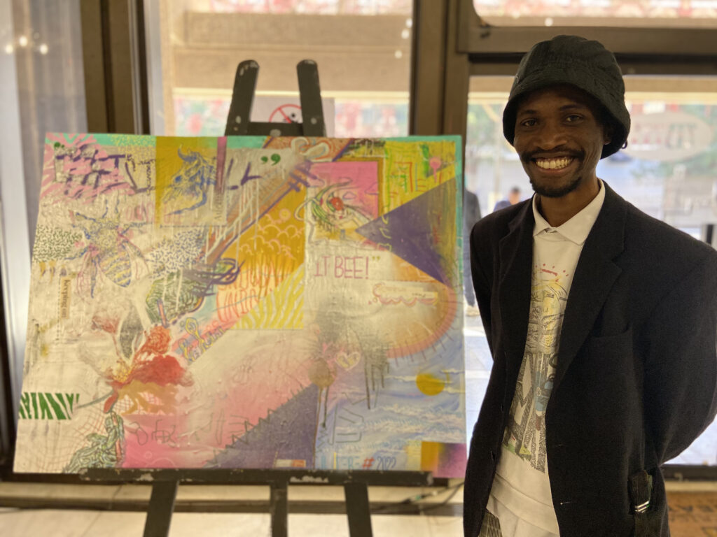 Dumisani Jere standing with his painting